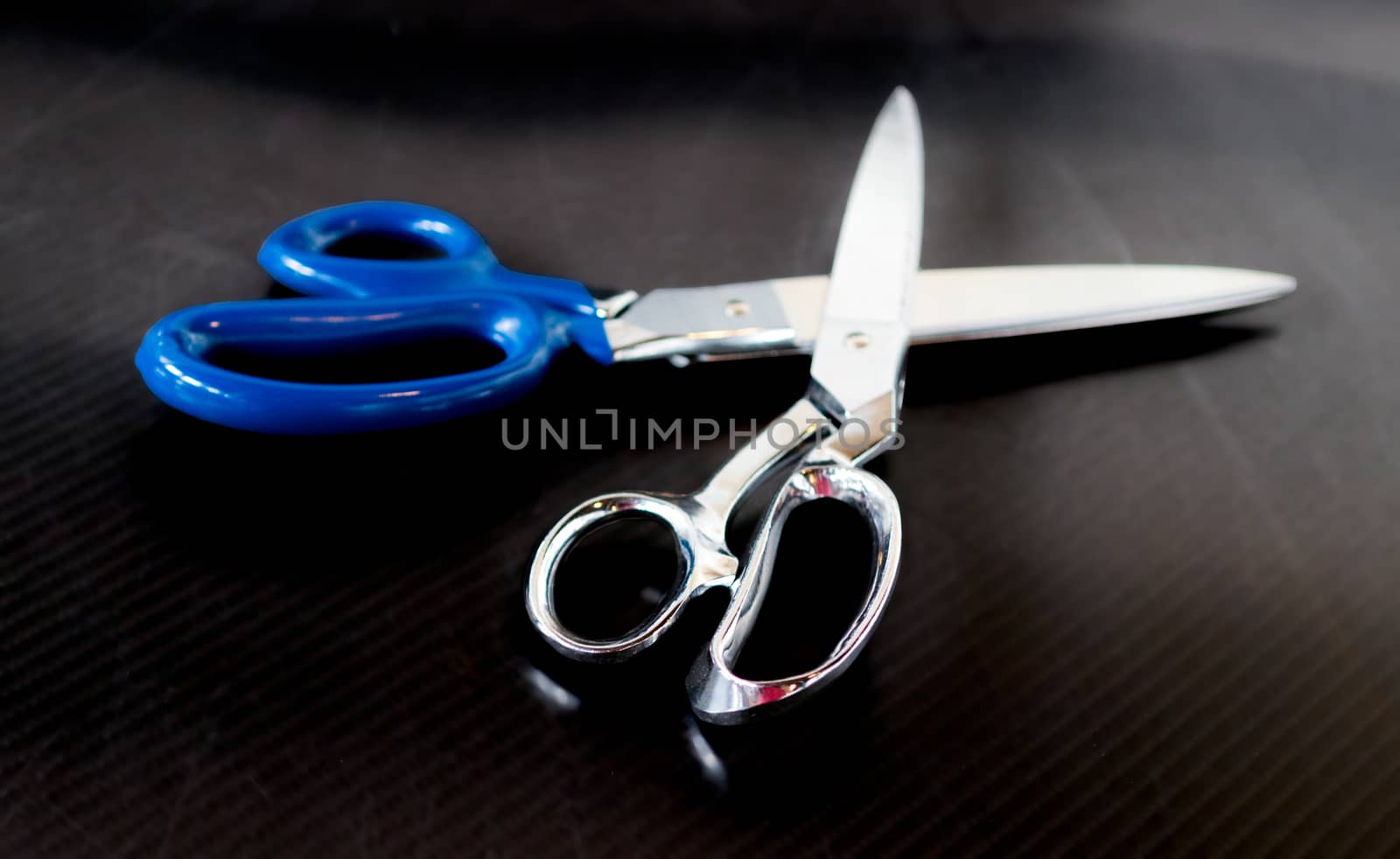 Stainless steel shears crossed on a carbon fiber table