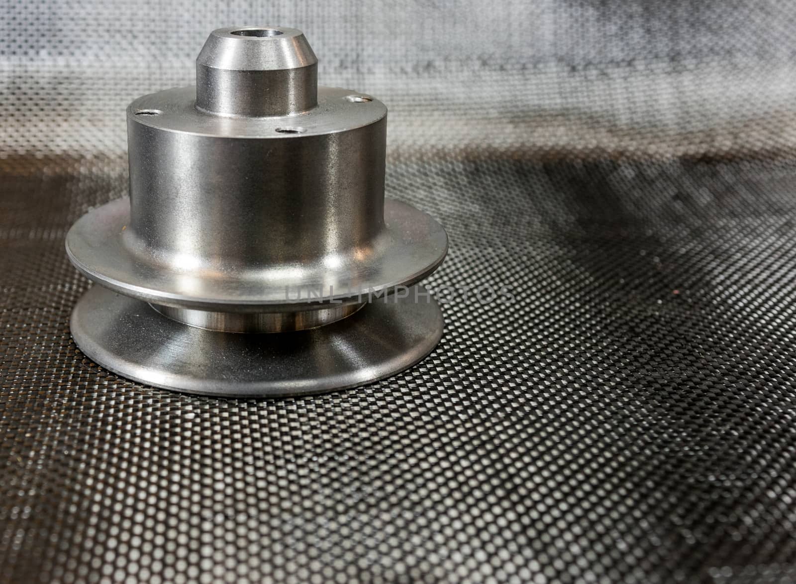 shiny steel milled billet Model A water pump pulley on plain weave carbon fiber