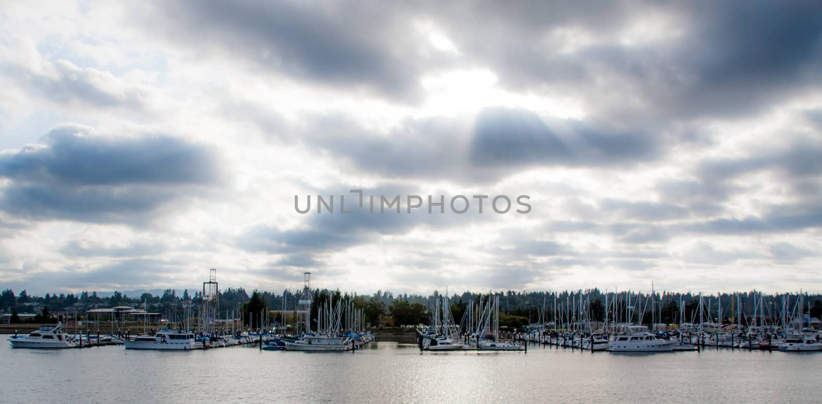 Cloudy marina with sun rays showing from the sky
