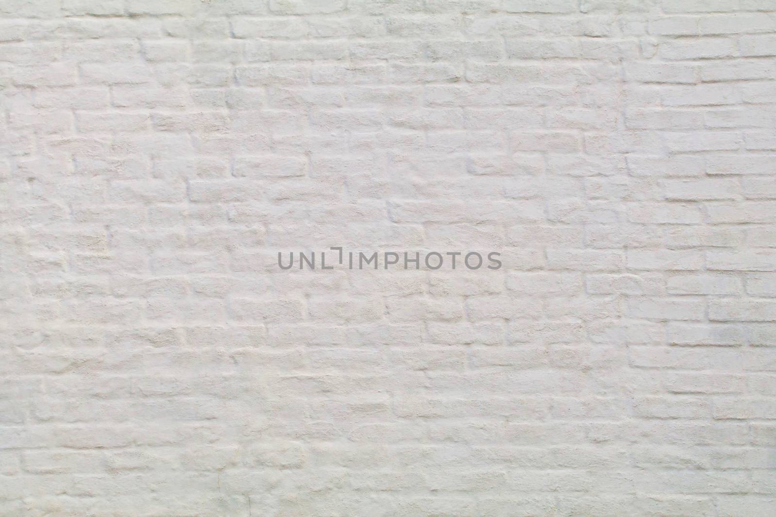 An old painted white brick wall shows.