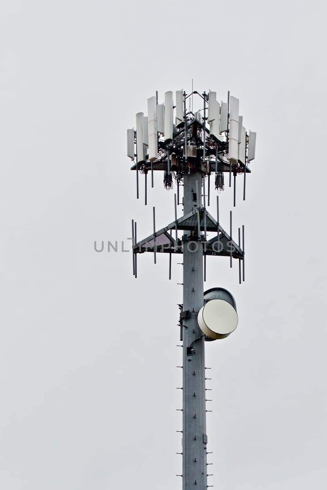 A hight capacity cell tower shows againtst the gray sky.