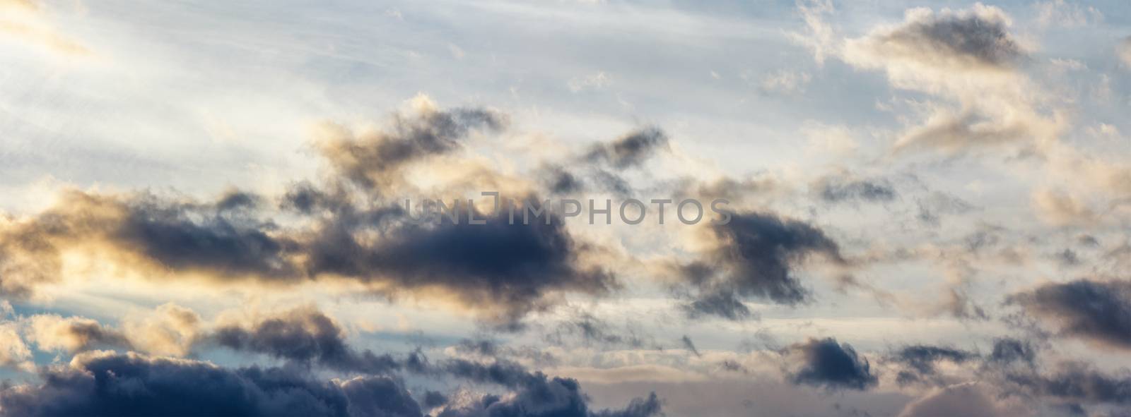 panorama of gorgeous cloudscape at sunset. beautiful nature background with golden fluffy clouds