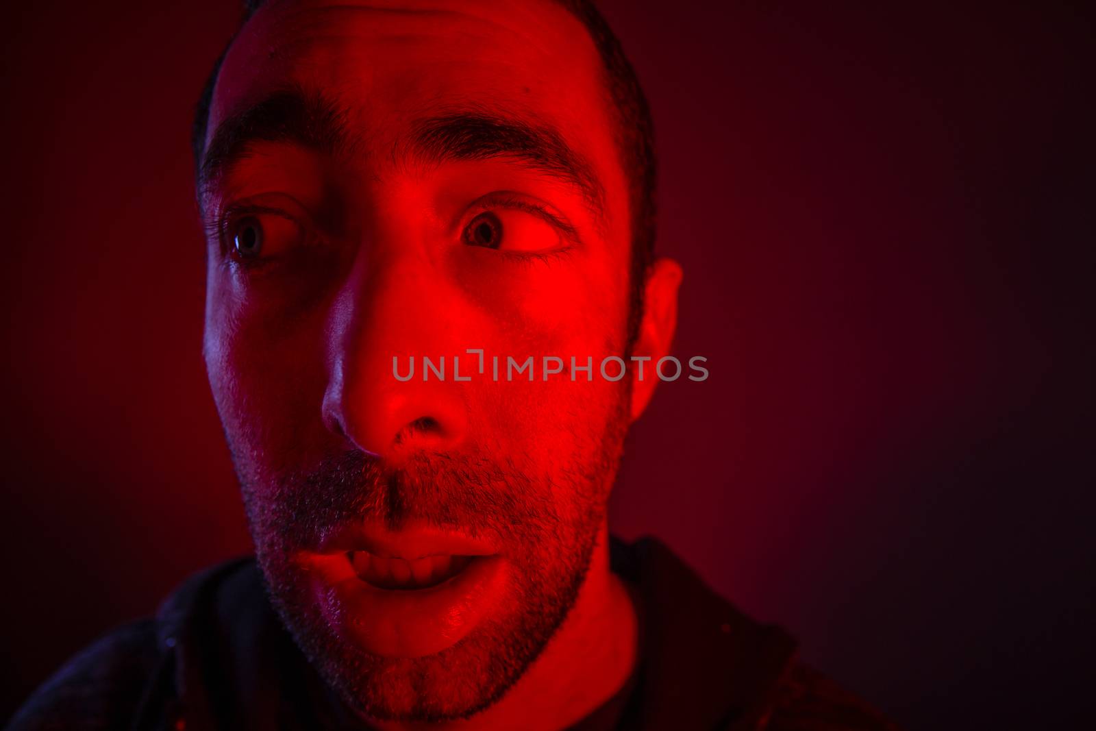 Man with shocked facial expression looking a side. Close up headshot portrait of nervous man.