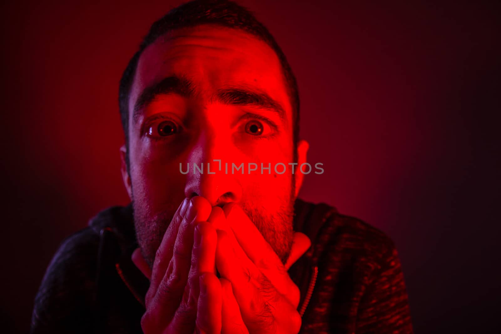 Stunned frightened man with surprised facial expression. Close up headshot portrait of shocked man with his hand on the face.