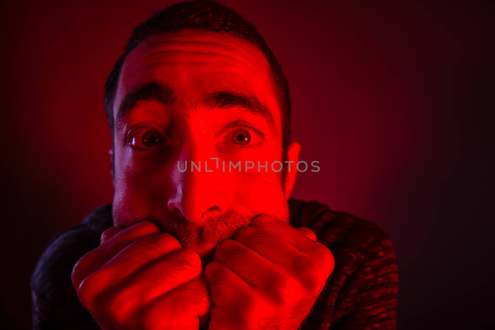 Stunned frightened man with surprised facial expression. Close up headshot portrait of shocked man with his hand on the face.