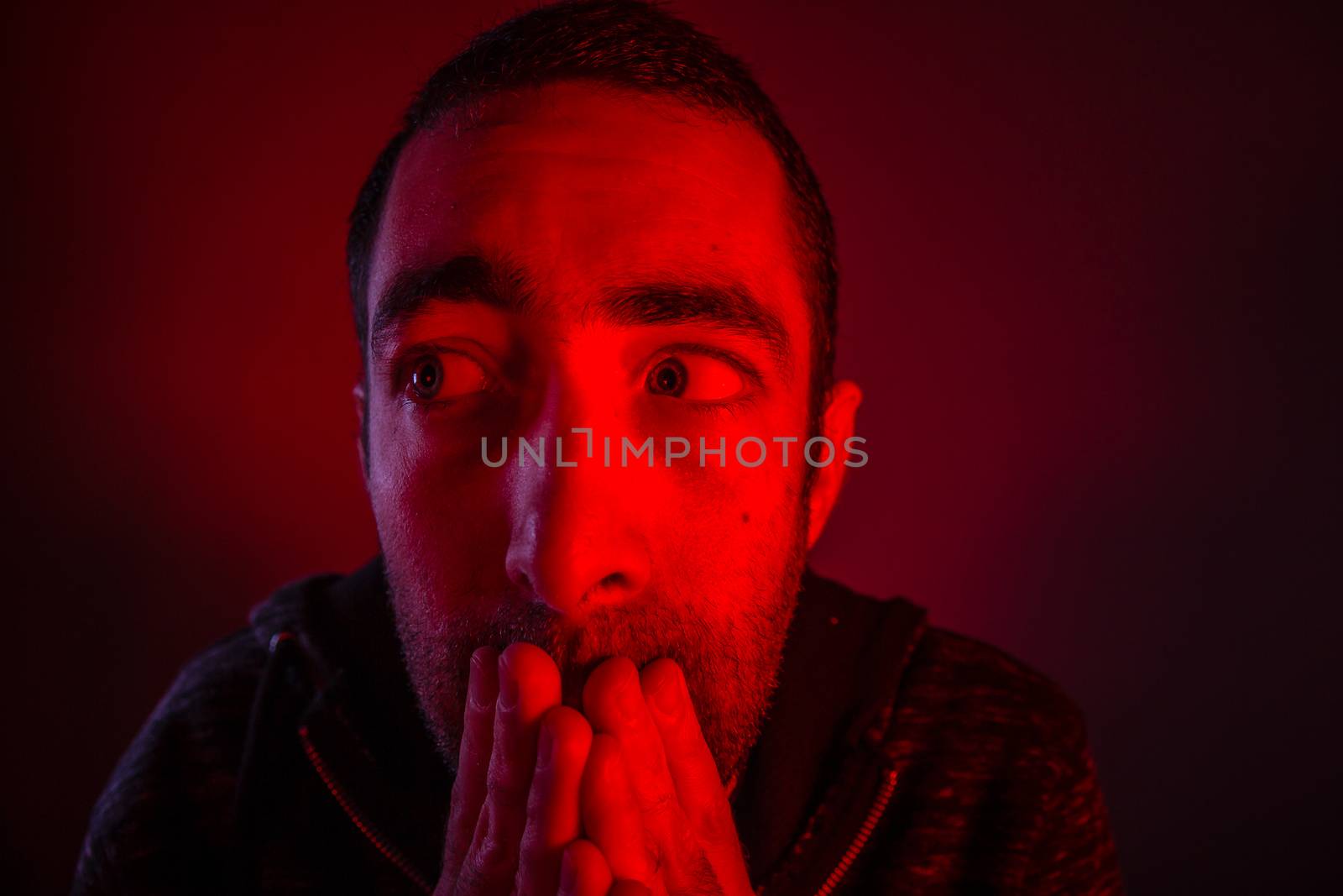 Stunned frightened man with surprised facial expression. Close up headshot portrait of shocked man with his hand on the face.