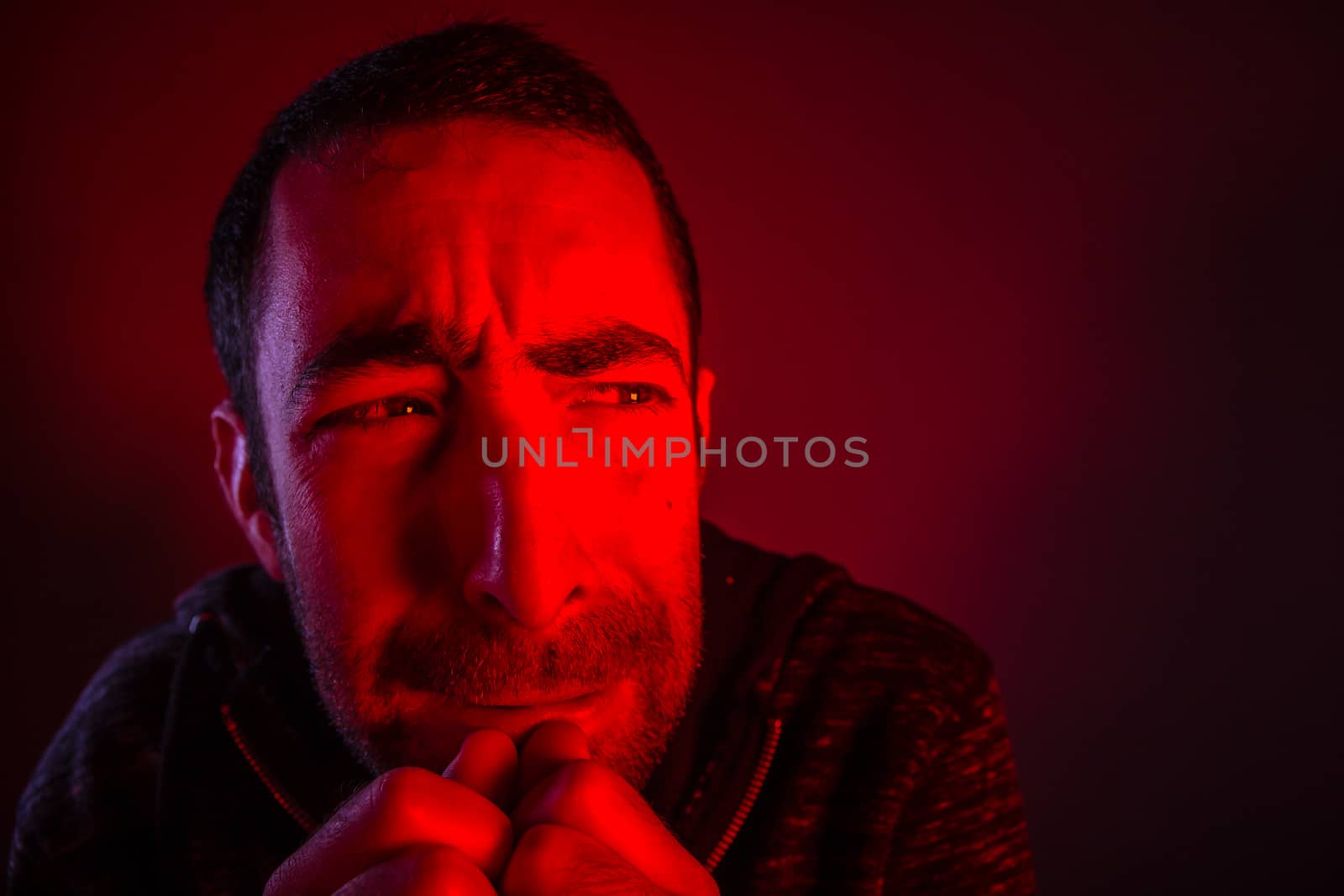 Man with terrified facial expression. Close up headshot portrait of crying man with his hand on the face.