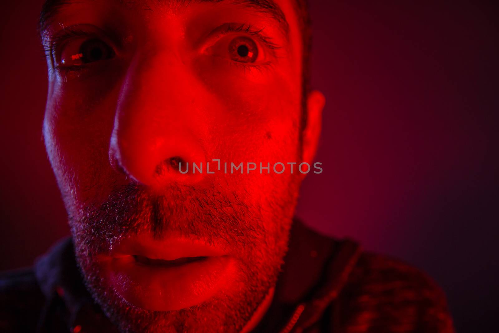 Man with shocked facial expression looking a side. Close up headshot portrait of nervous man.