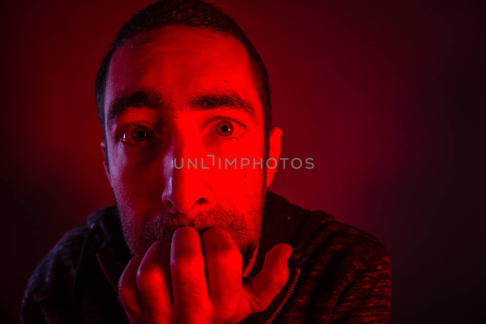 Stunned frightened man with surprised facial expression. Close up headshot portrait of shocked man with his hand on the face.