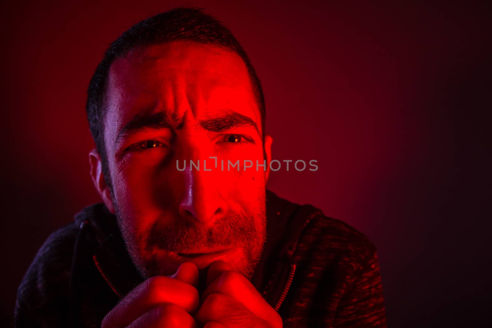 Man with terrified facial expression. Close up headshot portrait of crying man with his hand on the face.