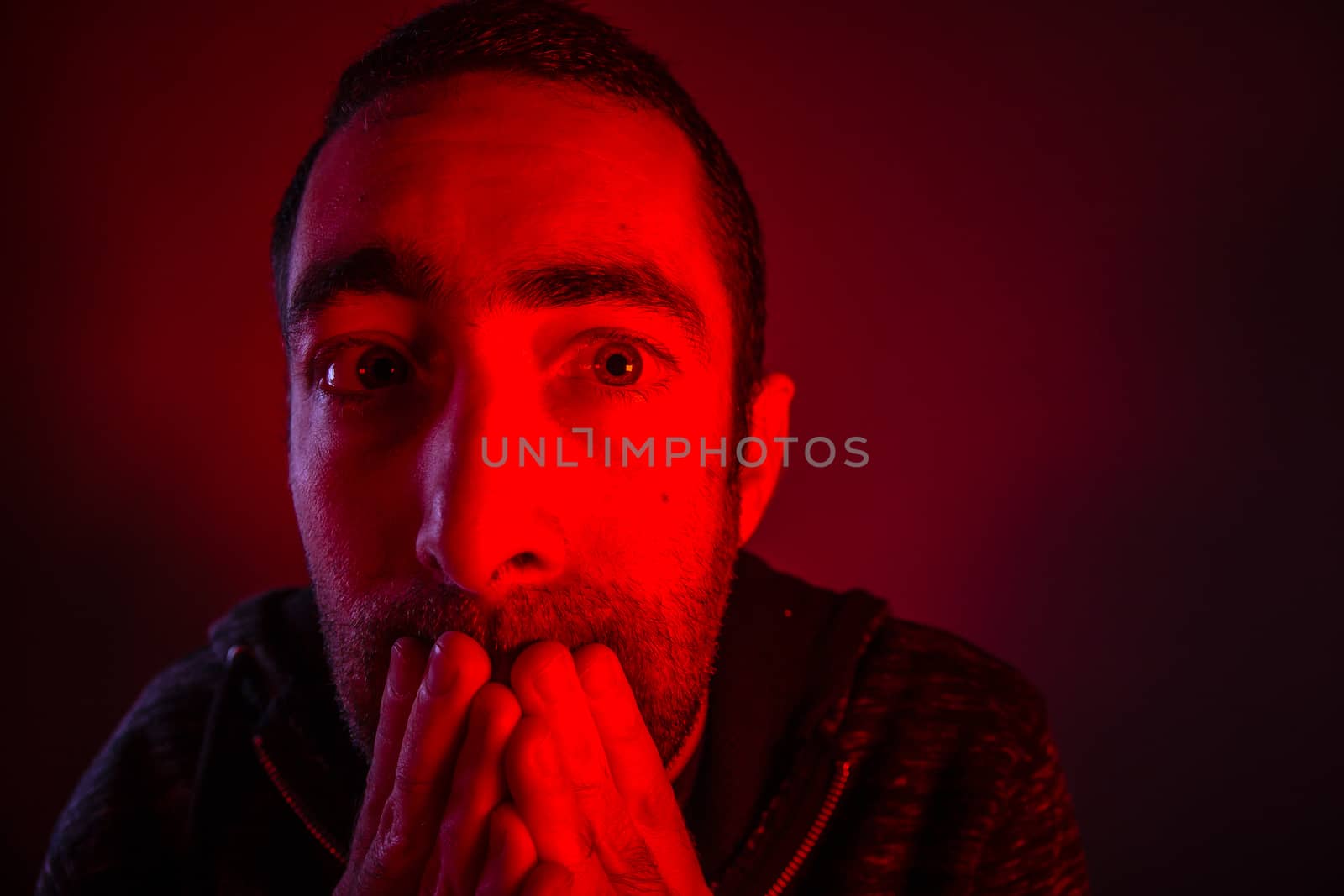 Stunned frightened man with surprised facial expression. Close up headshot portrait of shocked man with his hand on the face.