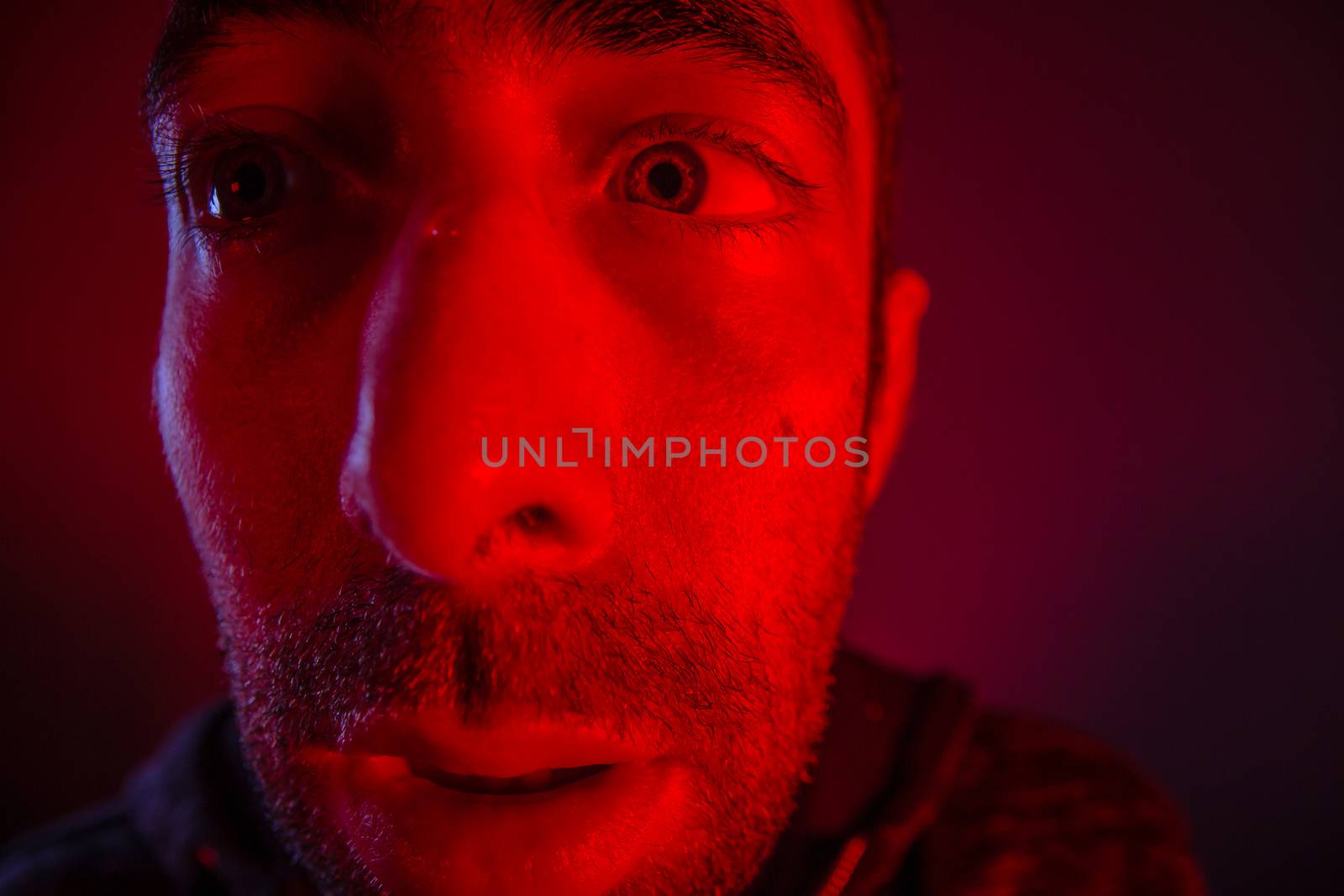 Man with shocked facial expression looking a side. Close up headshot portrait of nervous man.