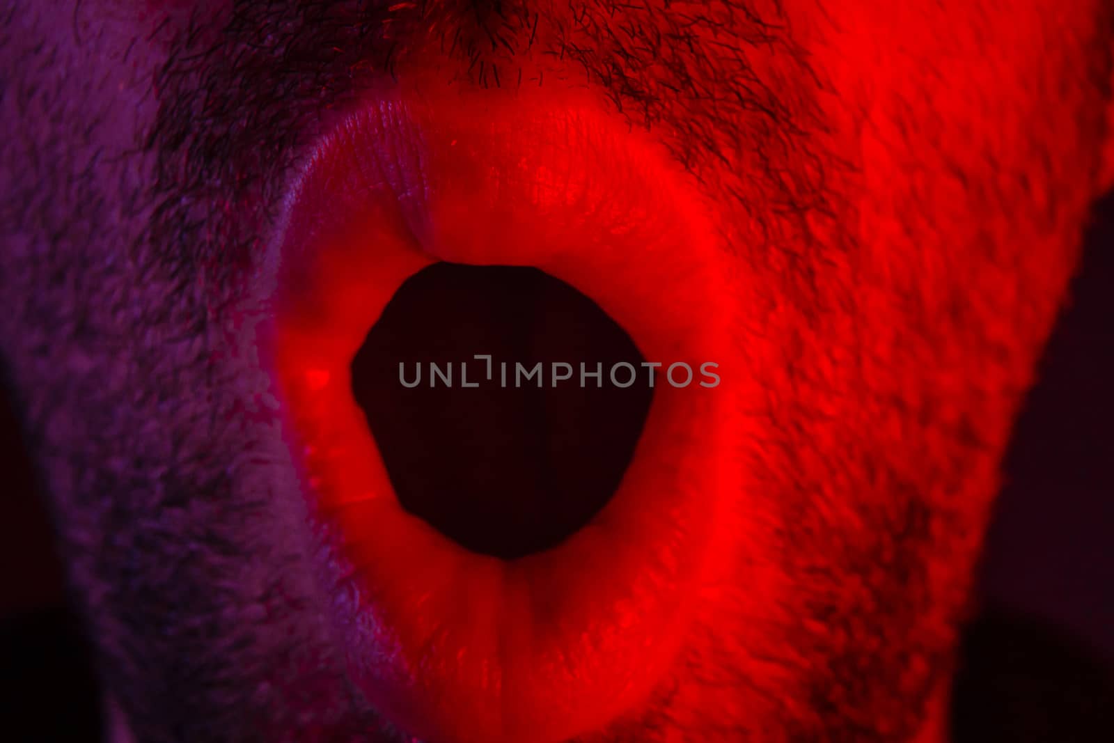 Macro closeup on man with surprised facial expression with opened mouth. Headshot portrait of shocked man.