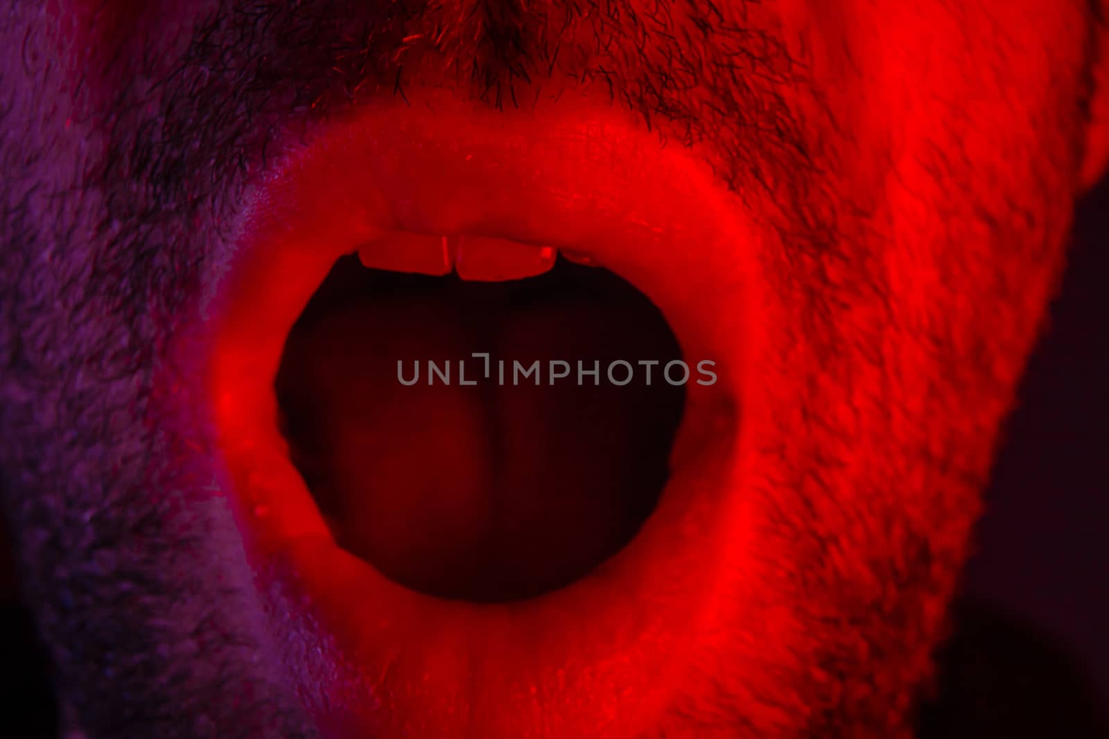 Macro closeup on man with surprised facial expression with opened mouth. Headshot portrait of shocked man.
