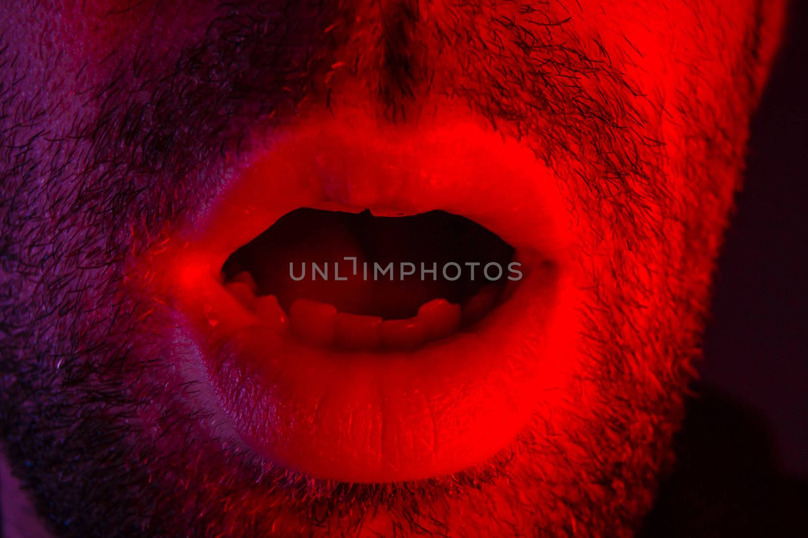 Macro closeup on man with surprised facial expression with opened mouth. Headshot portrait of shocked man.
