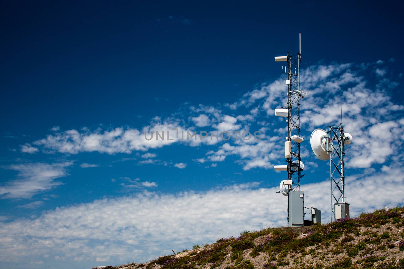 Mountain top weather station with a blue sky and scattered clouds