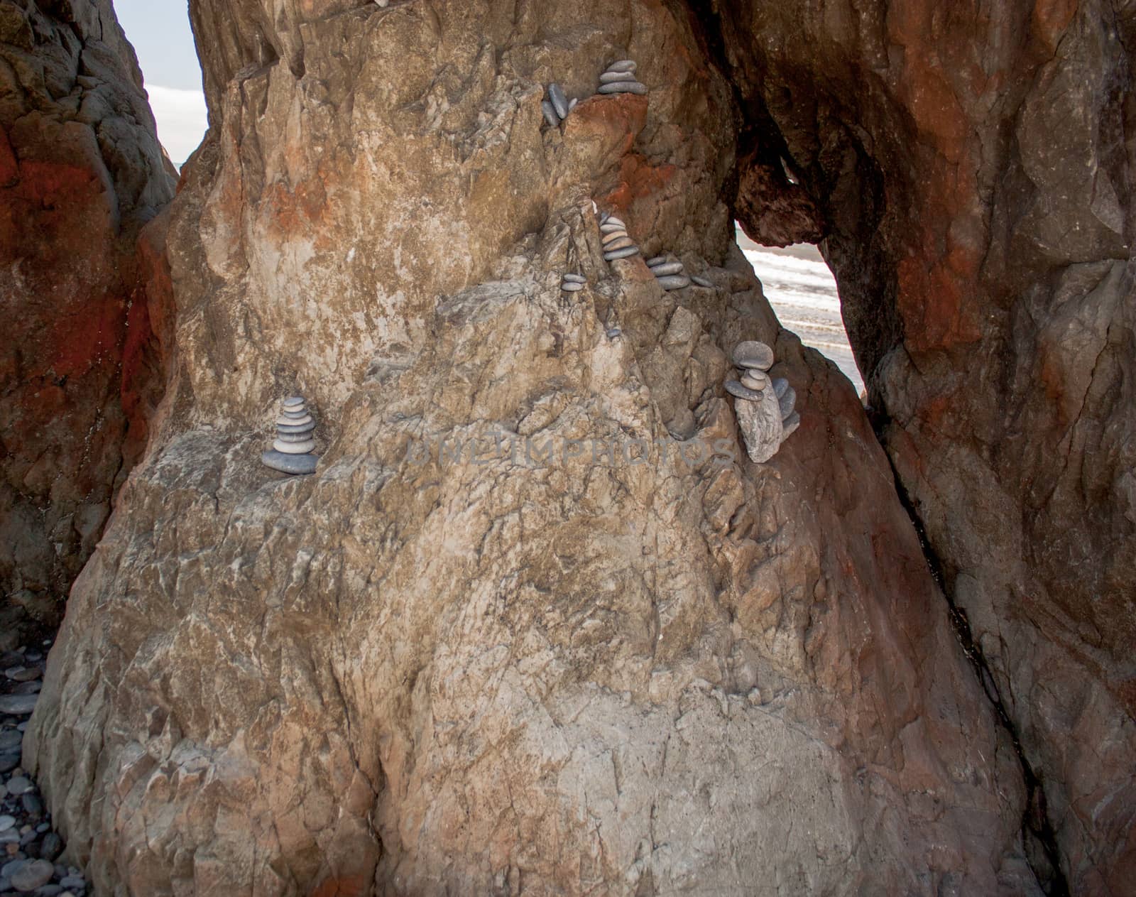 Small flat stones stacked in a rock formation at the beach in a cove