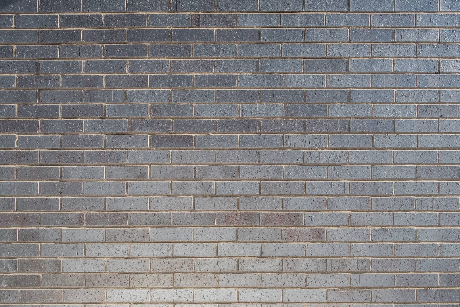 Texture of grey bricks with blue metallic reflects