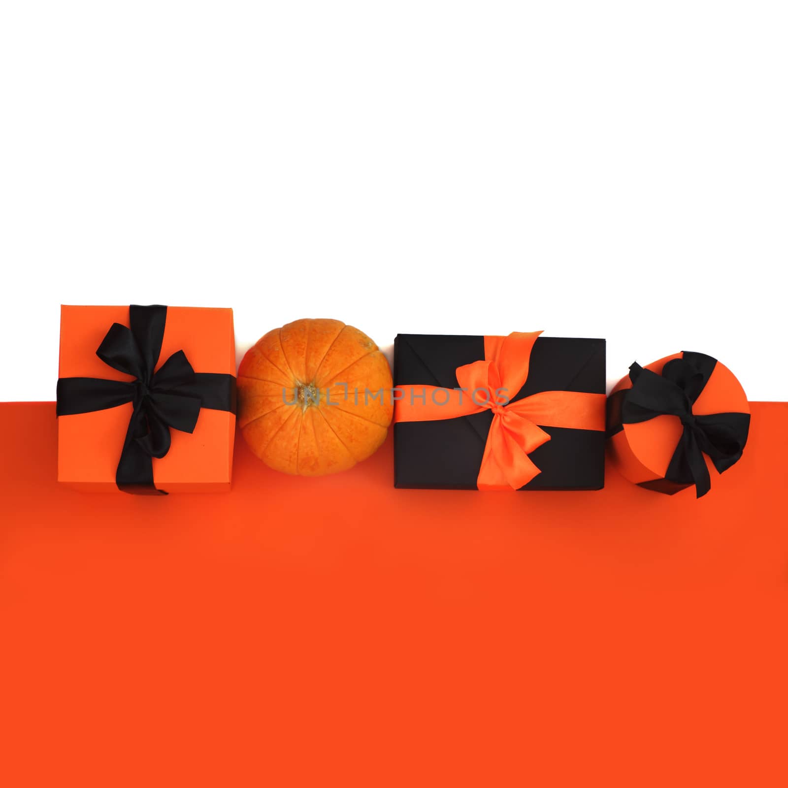 Halloween background with orange paper, pumpkin and gifts isolated on white background