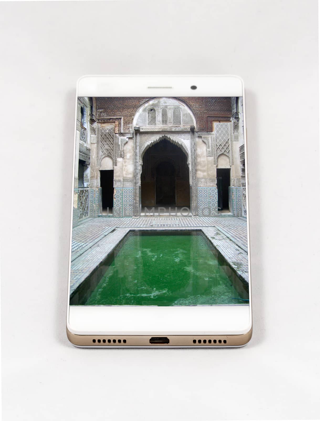 Modern smartphone with full screen picture of an ancient Medersa in Fez, Morocco. Concept for travel smartphone photography. All images in this composition are made by me and separately available on my portfolio