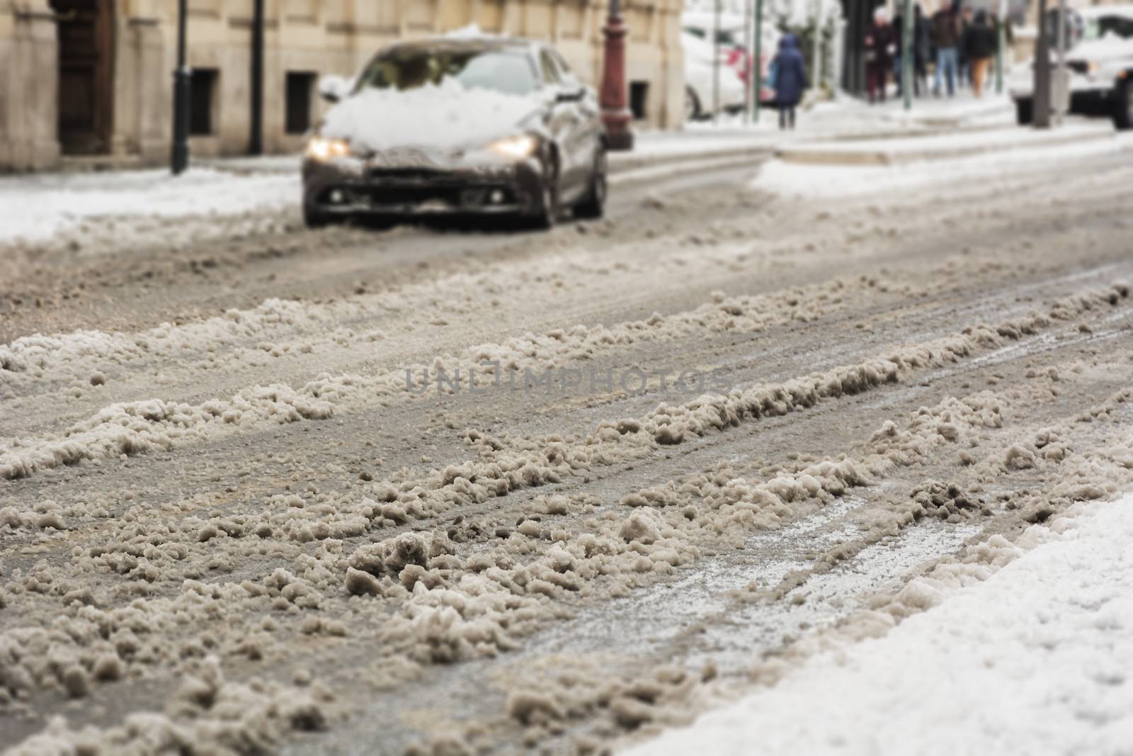 snow-covered road with a moving car in the background. Seasonal and transportation concept