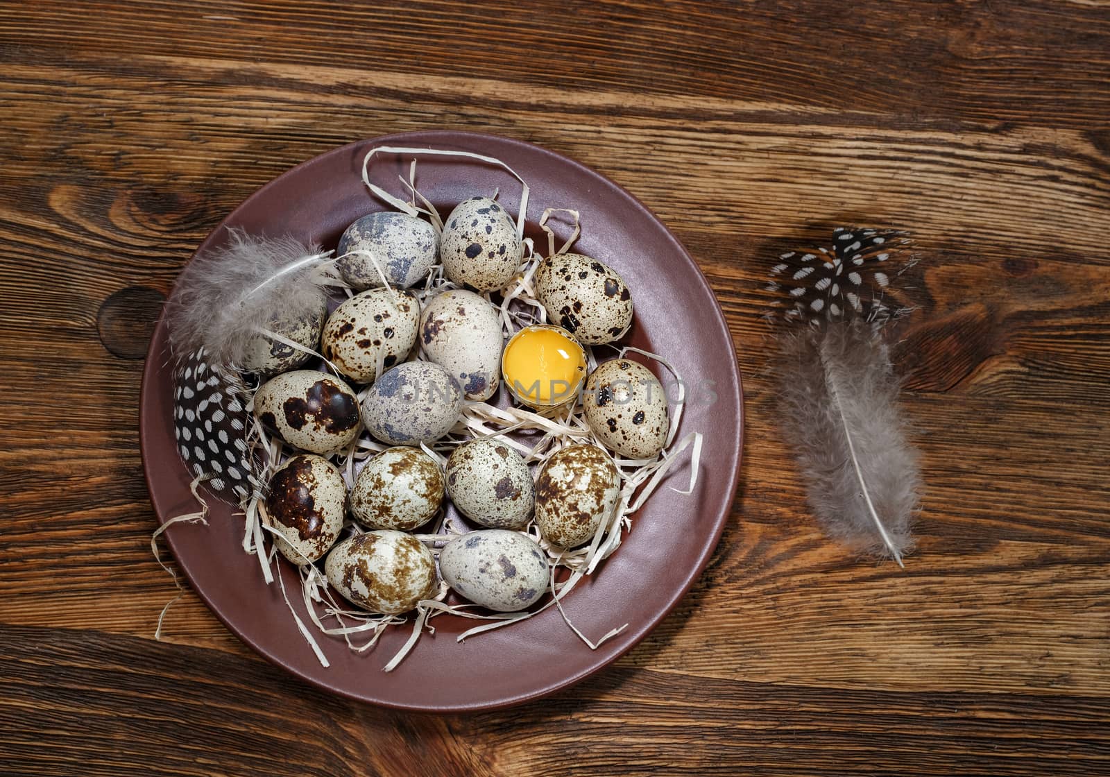 fresh quail eggs in a plate on a wooden background