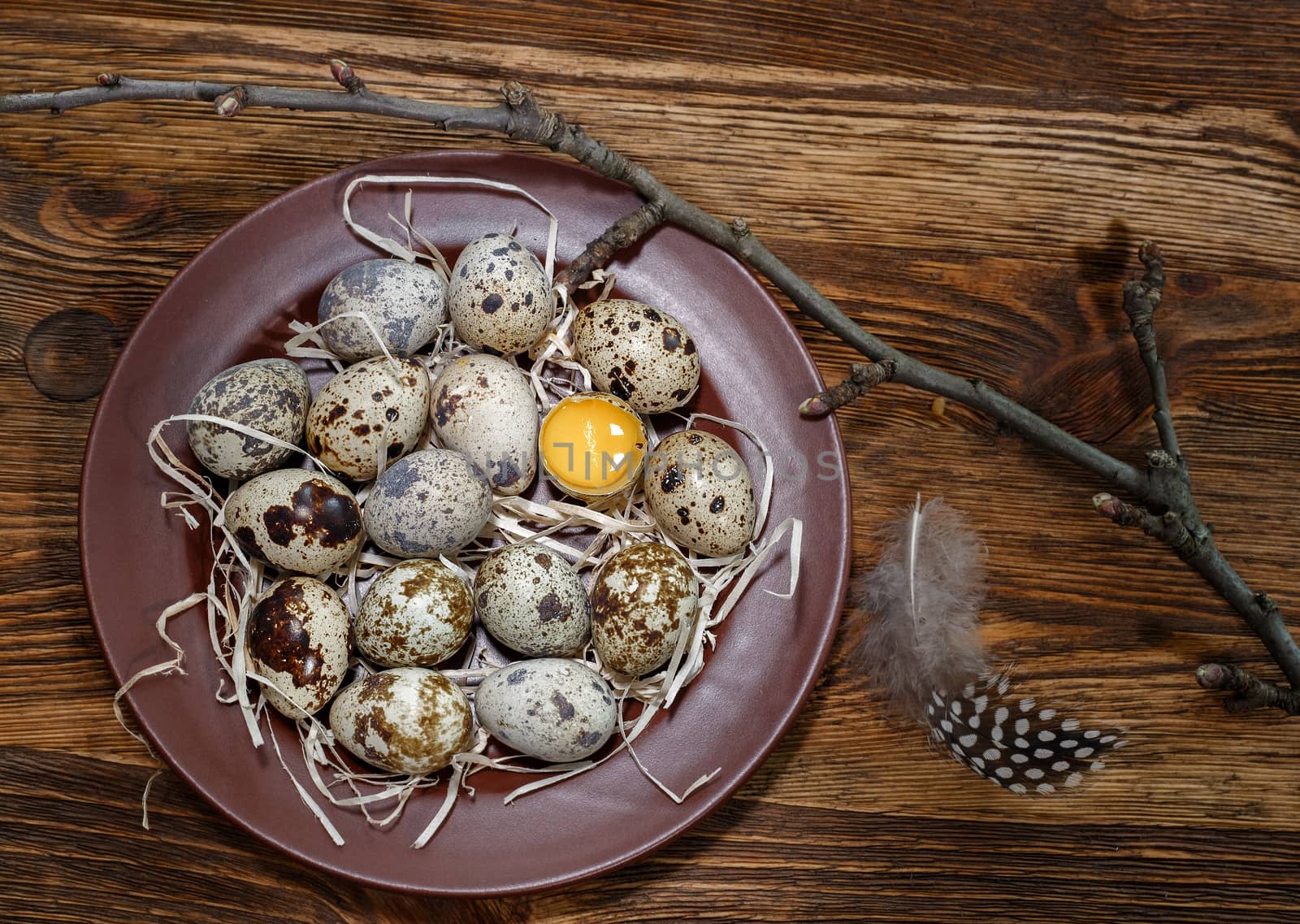 fresh quail eggs in a plate on a wooden background