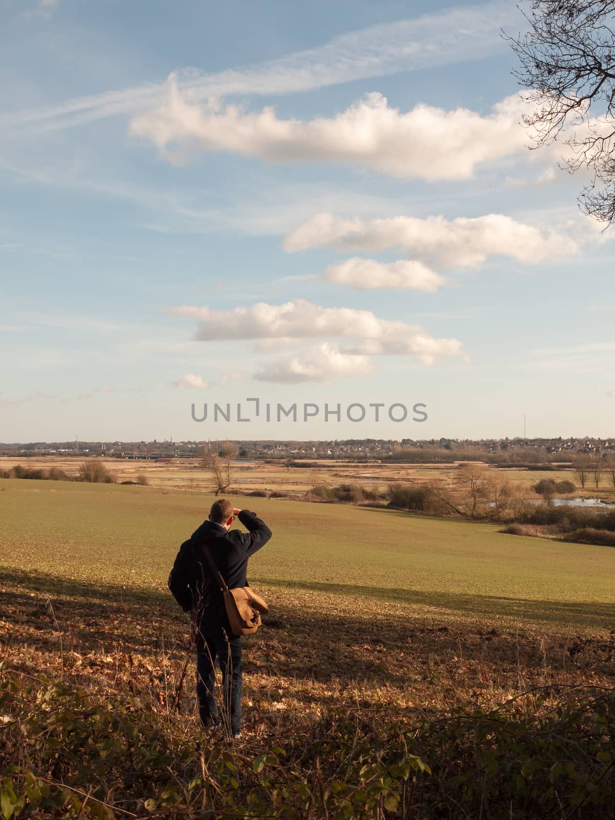 view of person looking out of large expanse space field agriculture nature landscape; essex; england; uk