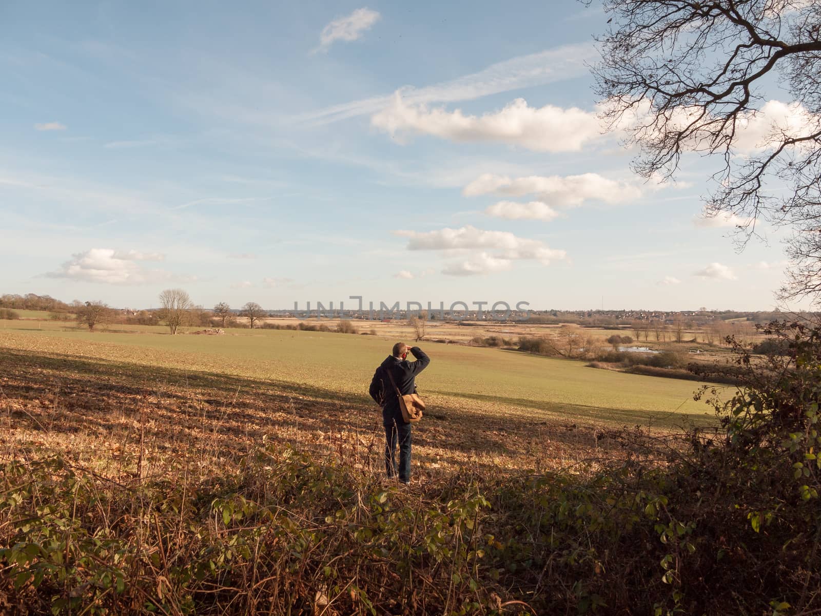 view of person looking out of large expanse space field agriculture nature landscape; essex; england; uk
