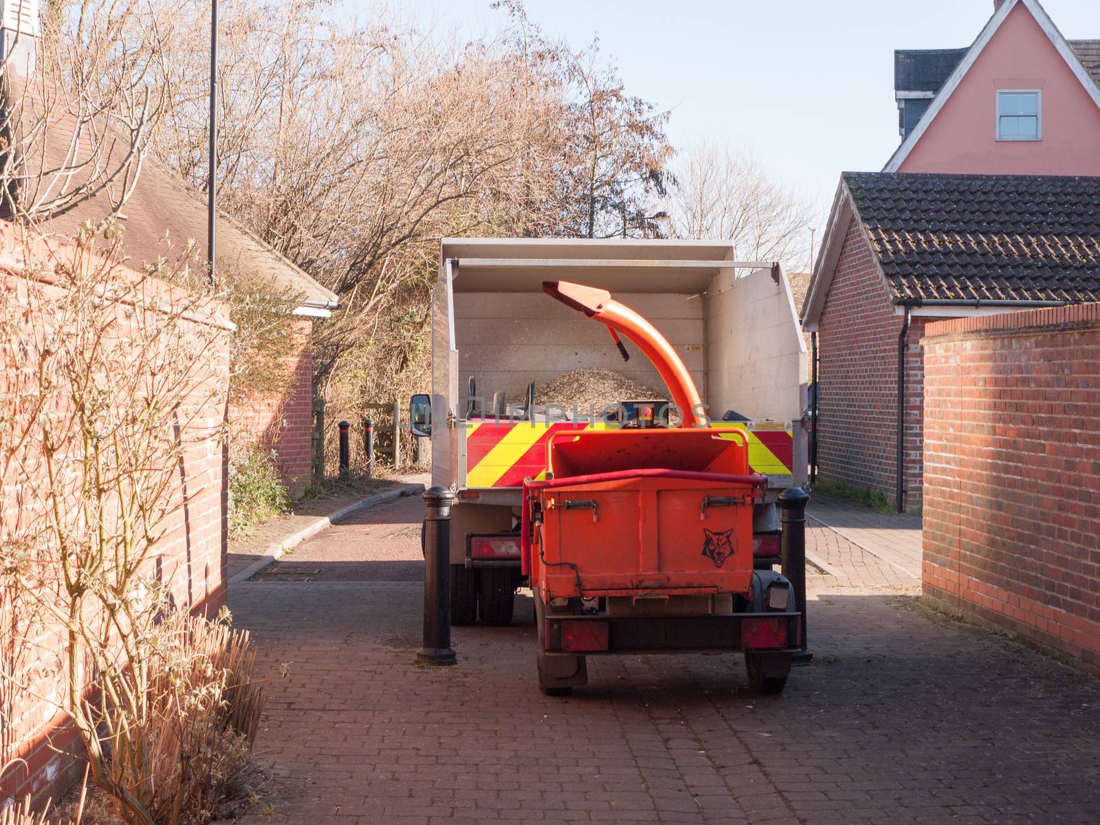 behind view of truck with red shredder machine behind street; essex; england; uk