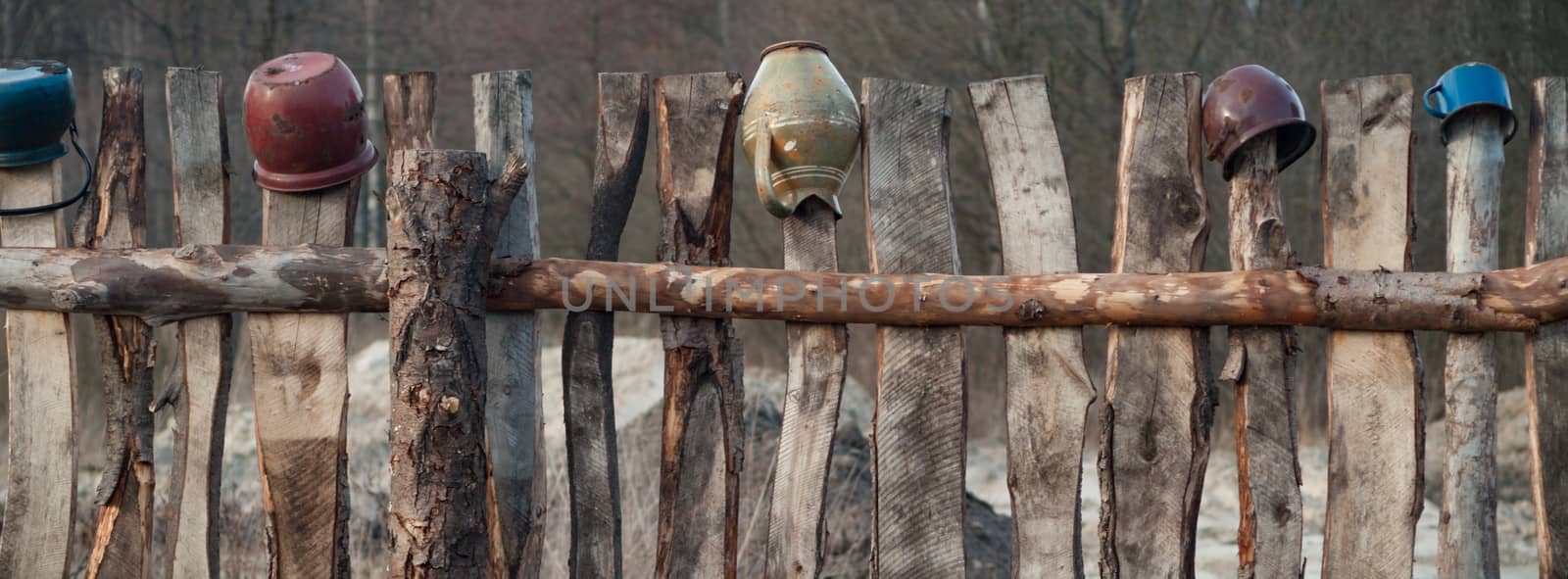 Old wooden boundary fence with nails on sunny day