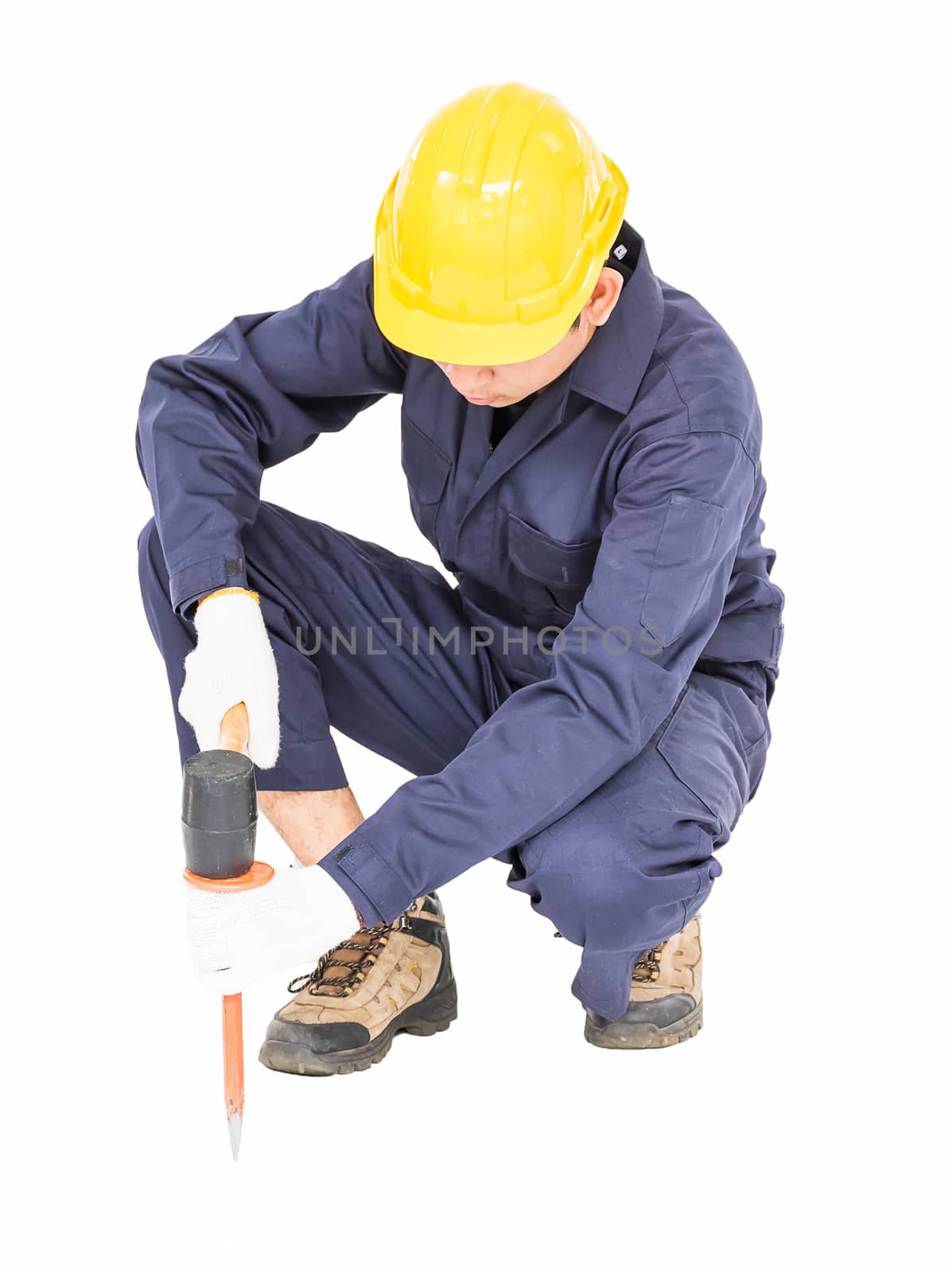 Young man in uniform sit and holding hammer was nailed to a cold chisel, Cut out isolated on white background