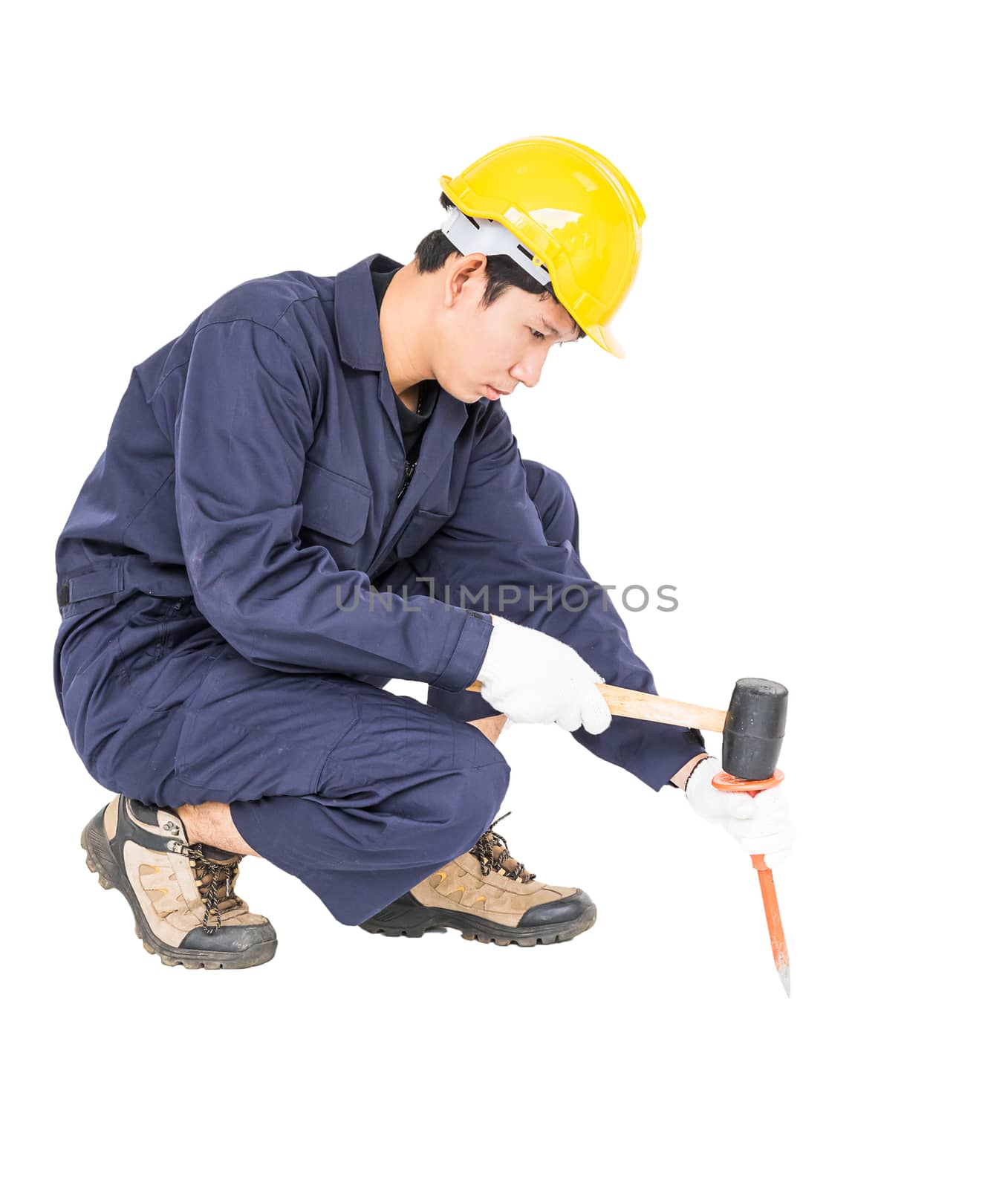 Young man in uniform sit and holding hammer was nailed to a cold chisel, Cut out isolated on white background