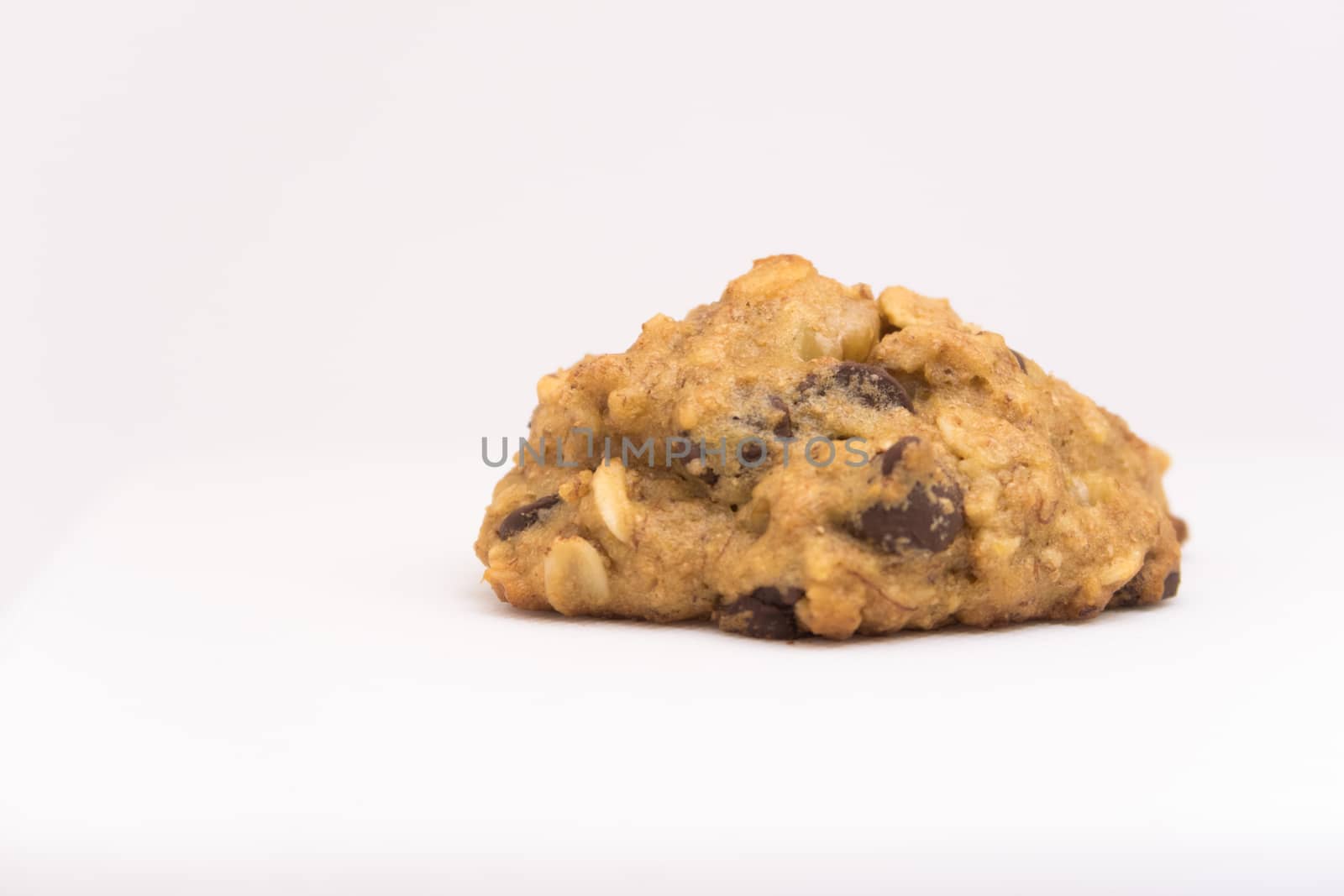 Isolated cookie with chocolate chips and oat flakes