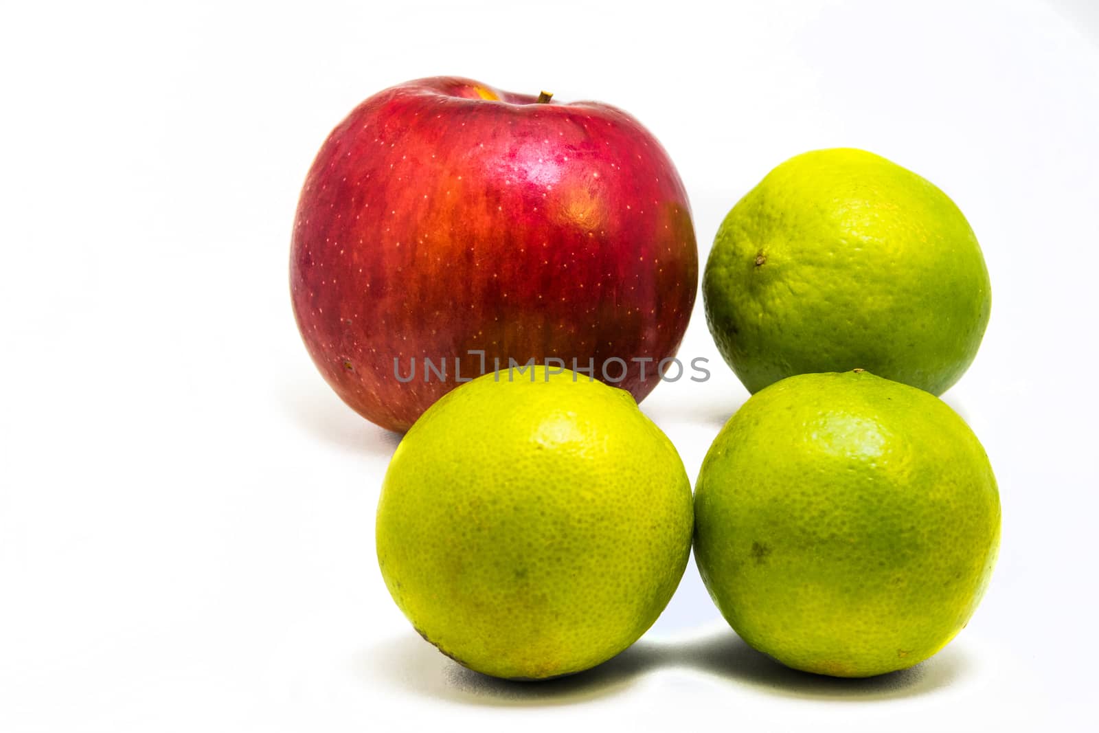 One red apple and three green lime isolated on white