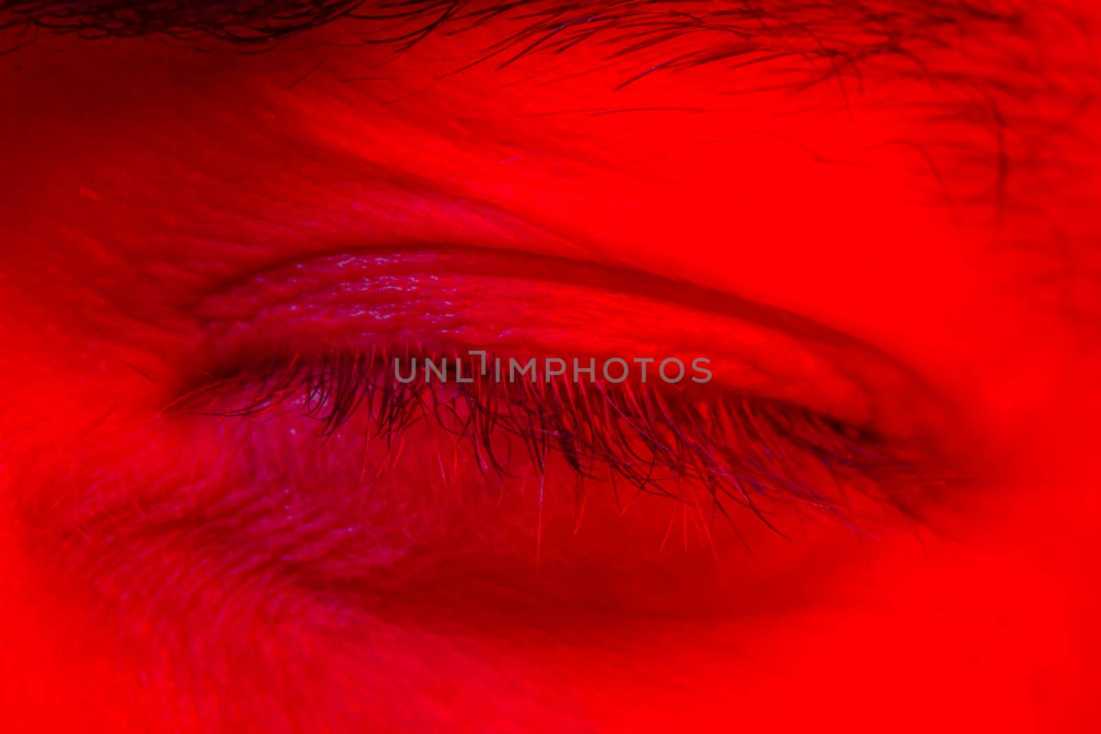 Macro close up on man with peaceful calm facial expression with close eyes. Portrait of meditating and thinking young man looking at camera.
