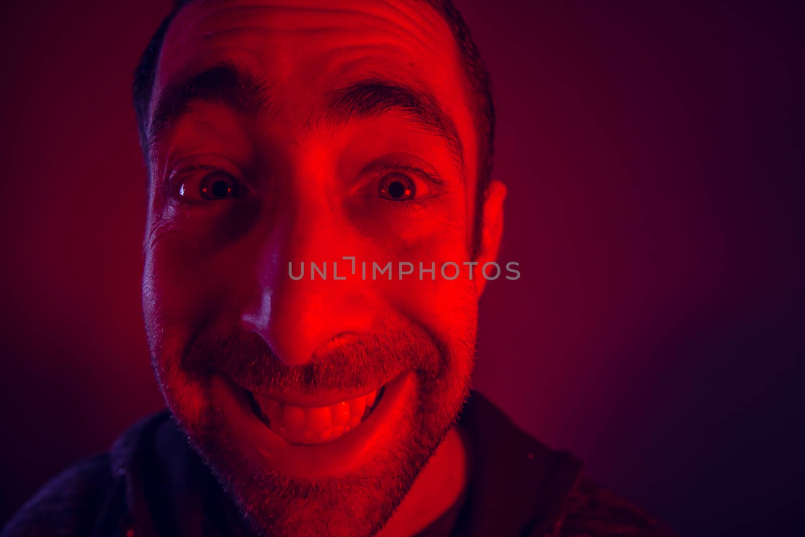 Man with happy smiling facial expression. Close up portrait of happy young man looking at camera.
