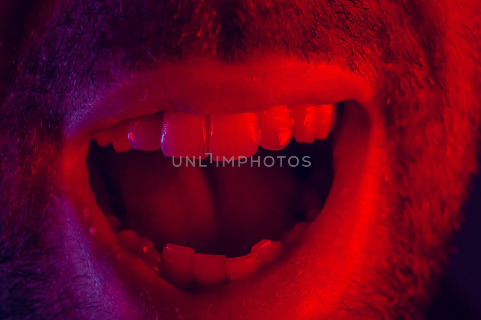 Macro close up on man with happy smiling facial expression. Portrait of happy young man looking at camera.