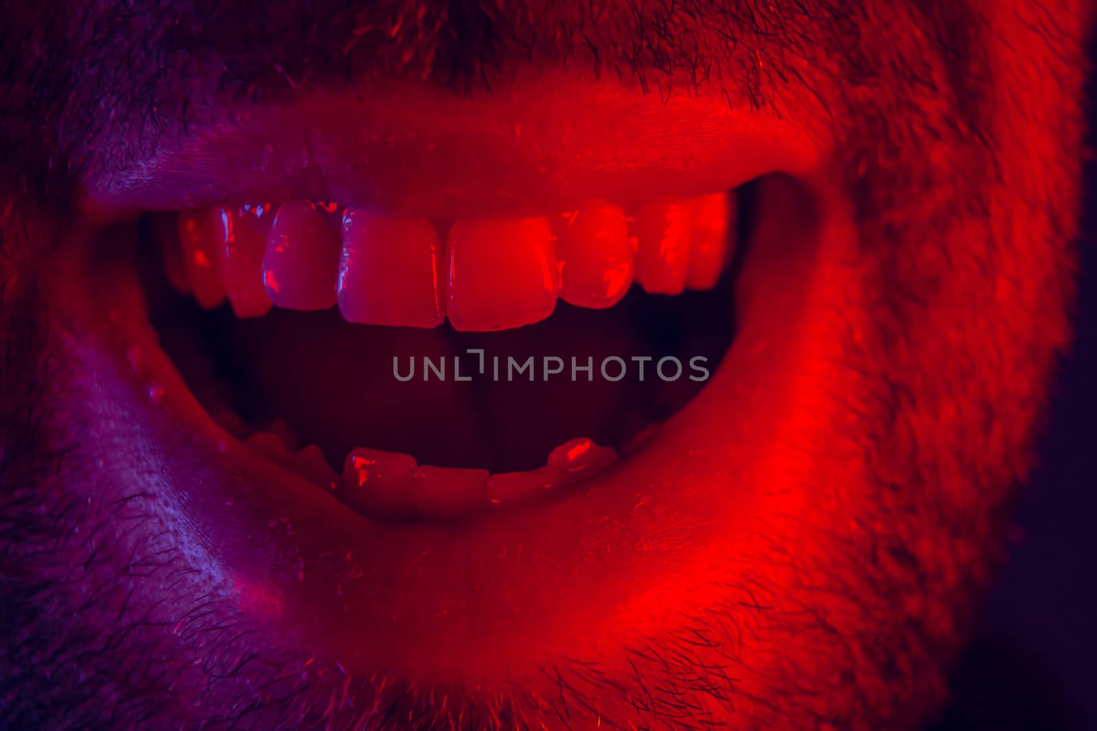 Macro close up on man with happy smiling facial expression. Portrait of happy young man looking at camera.