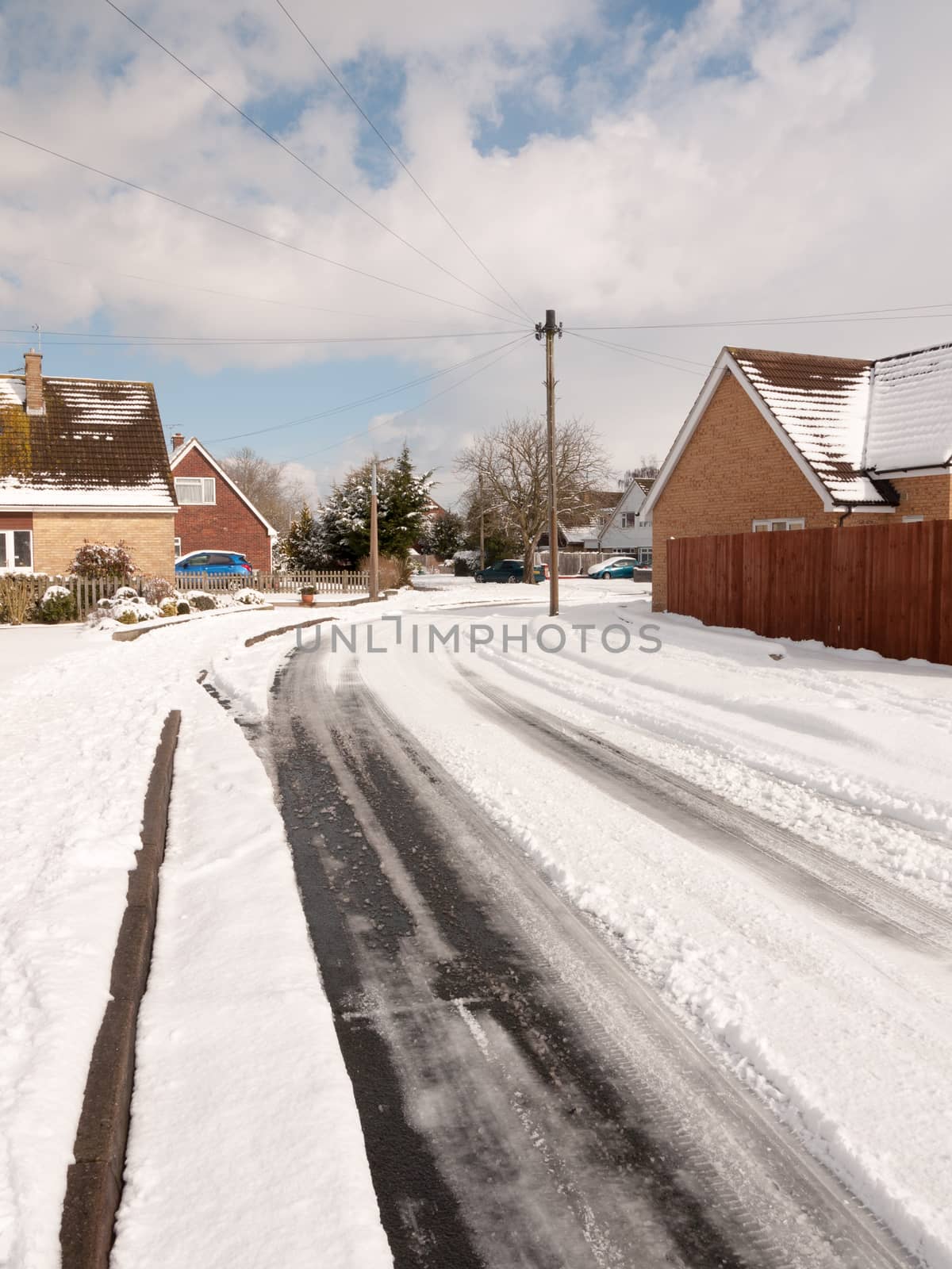 winter road through uk estate tracks no cars empty path snow by callumrc