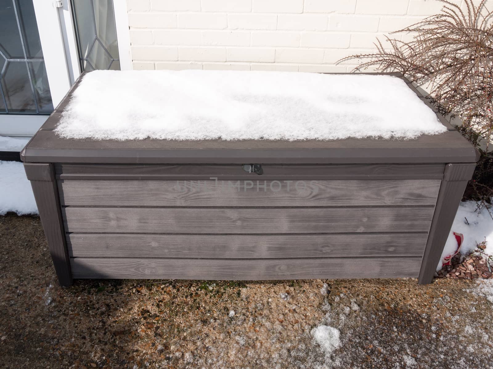 snow on top of plastic container outside in garden closed locked; essex; england; uk