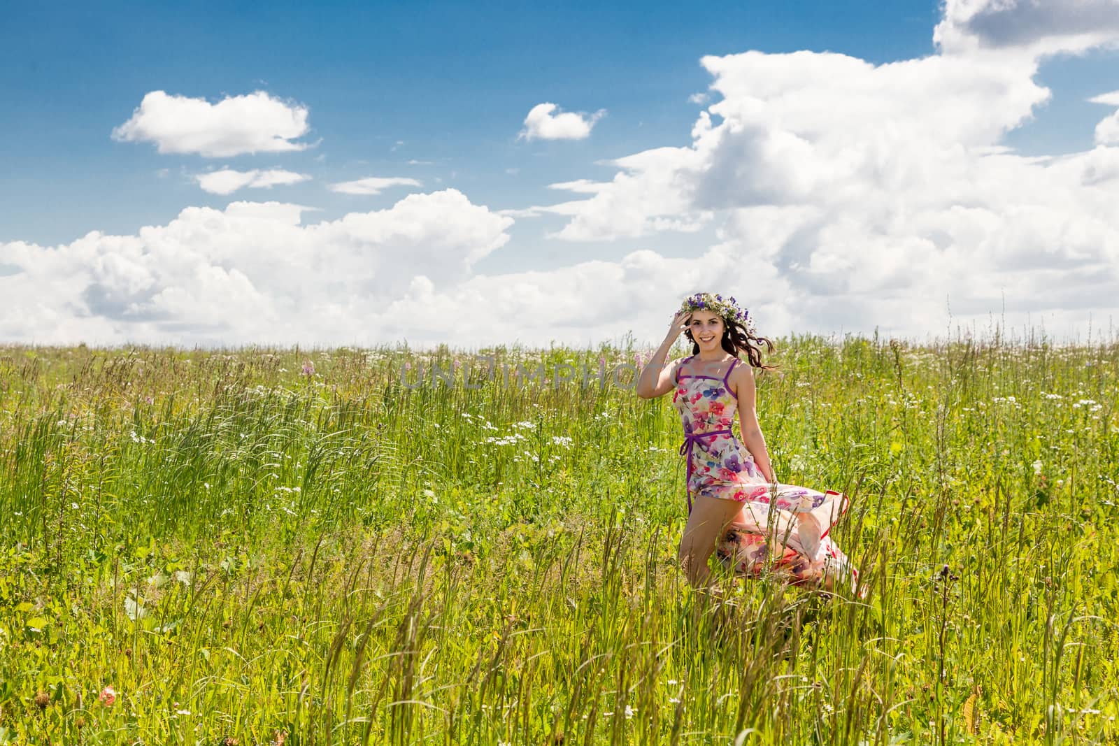 Portrait of the beautiful girl running in the field