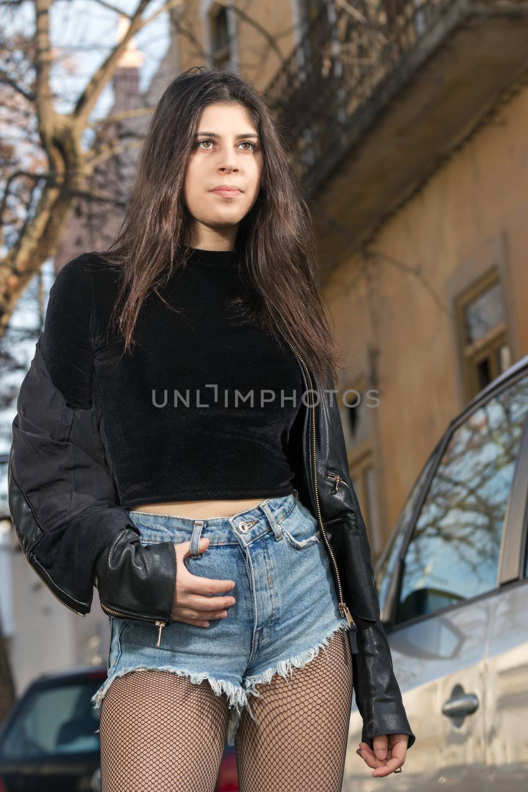 Close view of a beautiful young woman with short blue jeans on the urban city.