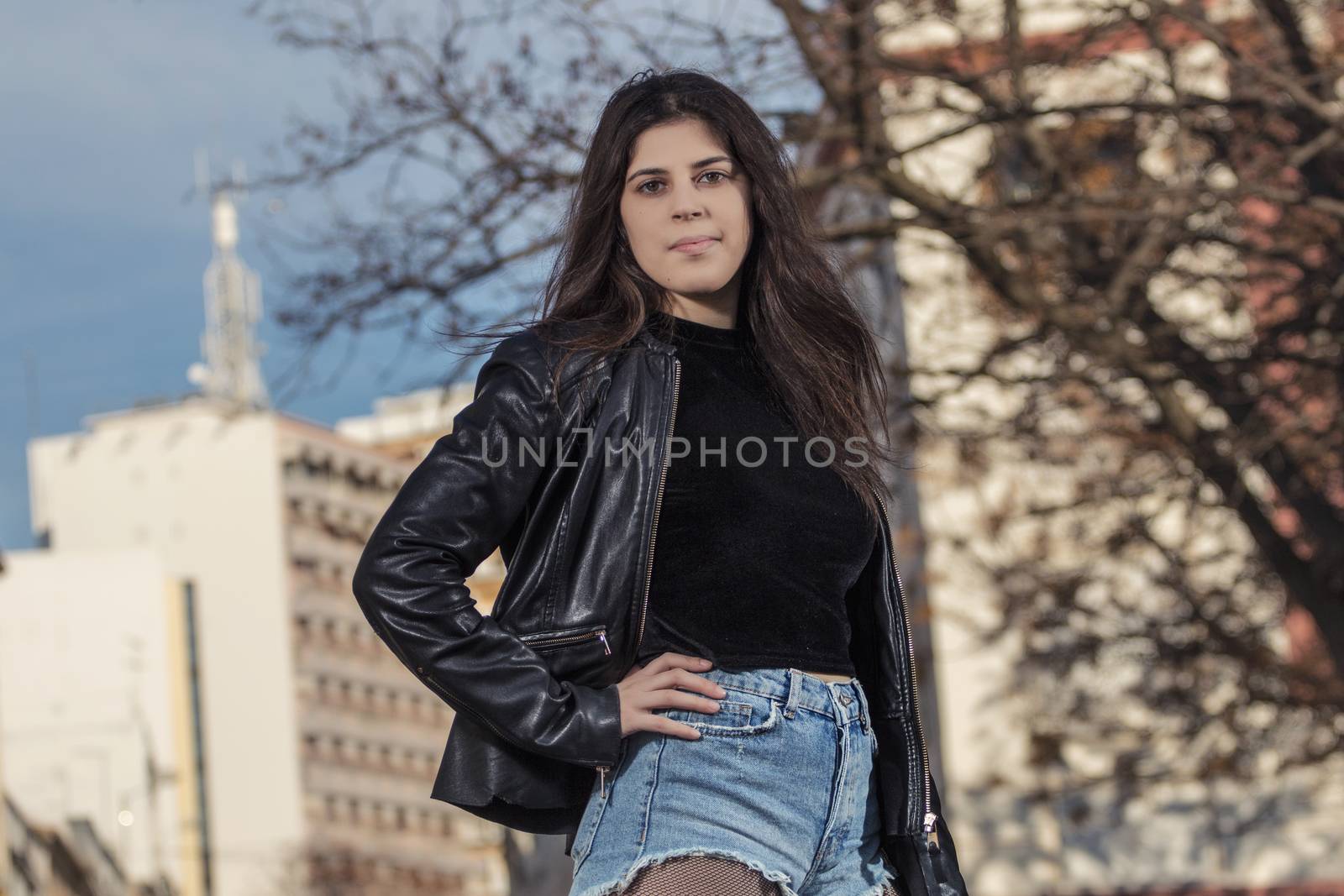 Close view of a beautiful young woman with short blue jeans on the urban city.