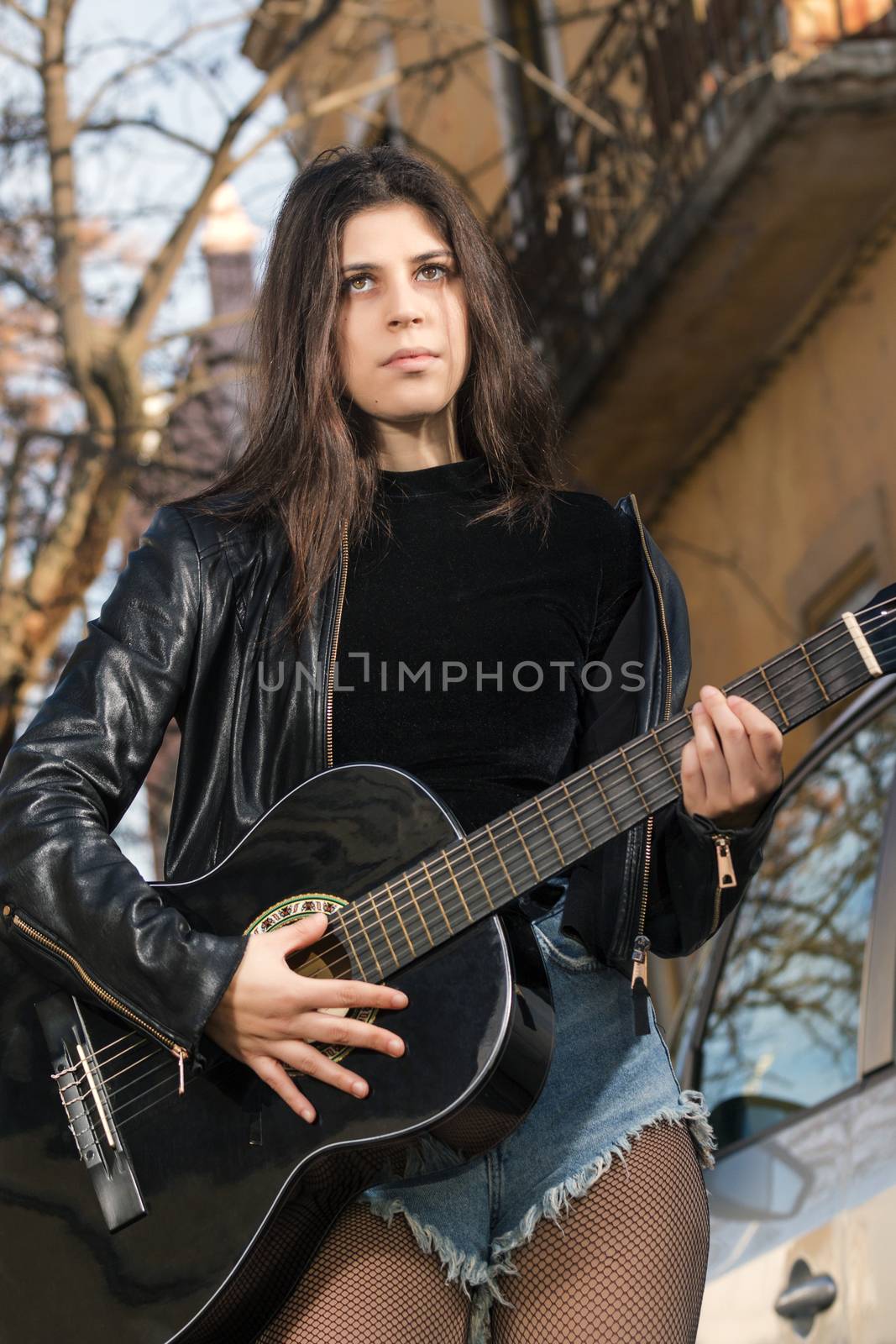 Young woman with classic guitar by membio