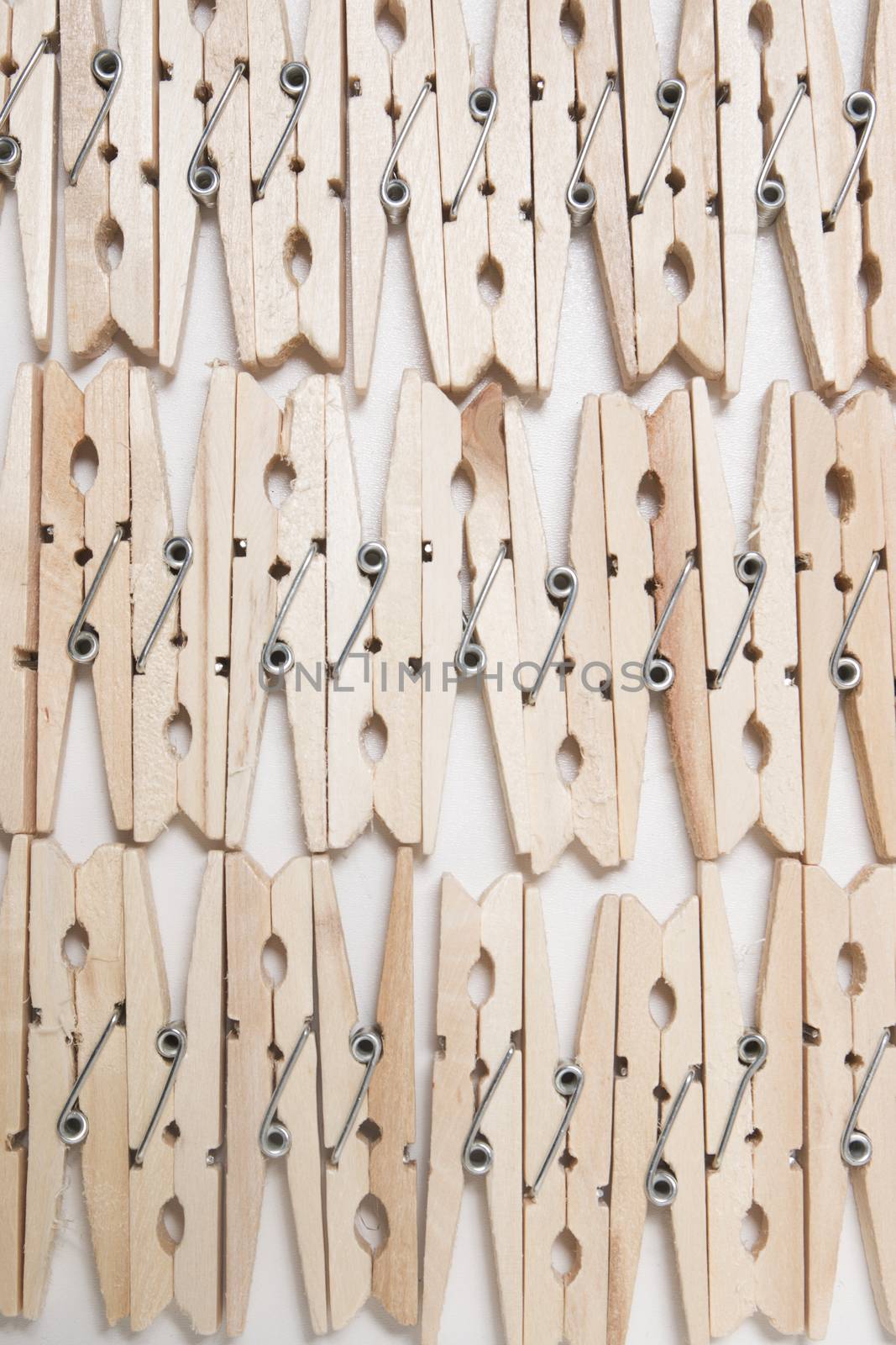 Aligned clothing pegs isolated on a white background.