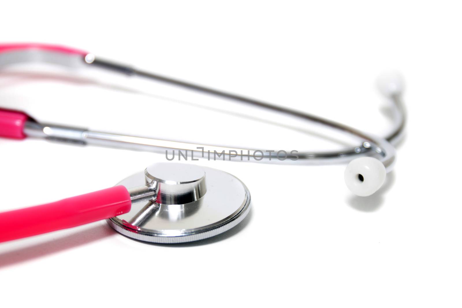 Close up view of a pink doctor's stethoscope isolated on a white background.