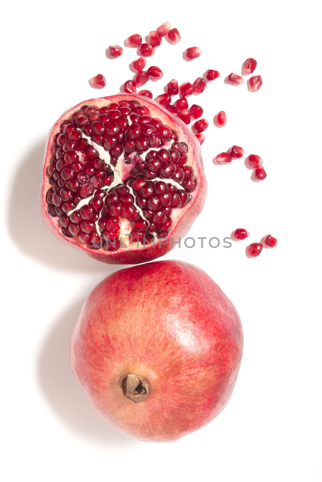 Close up view of tasty pommegranate fruit isolated on a white background.