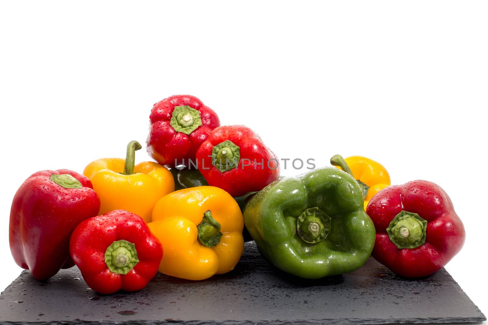 colorful bell peppers on a black stone of schist.
