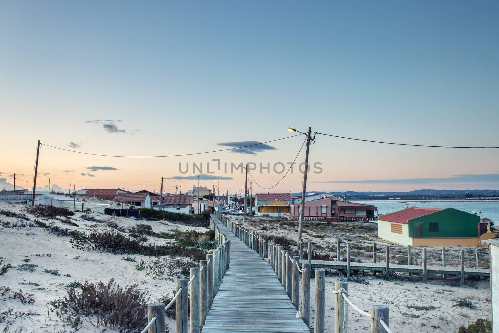 Landscape view of the Island of Faro dunes and houses at sunset, Algarve, Portugal.